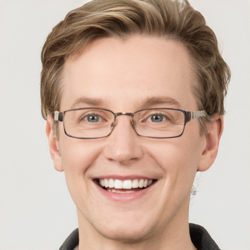 Joyful white adult male with short  brown hair and blue eyes