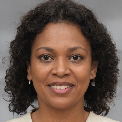 Joyful black young-adult female with medium  brown hair and brown eyes