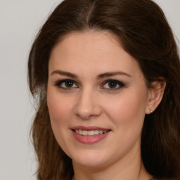 Joyful white young-adult female with long  brown hair and green eyes