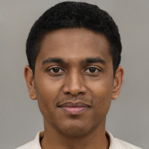 Joyful black young-adult male with short  brown hair and brown eyes