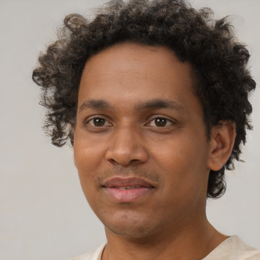 Joyful black young-adult male with short  brown hair and brown eyes