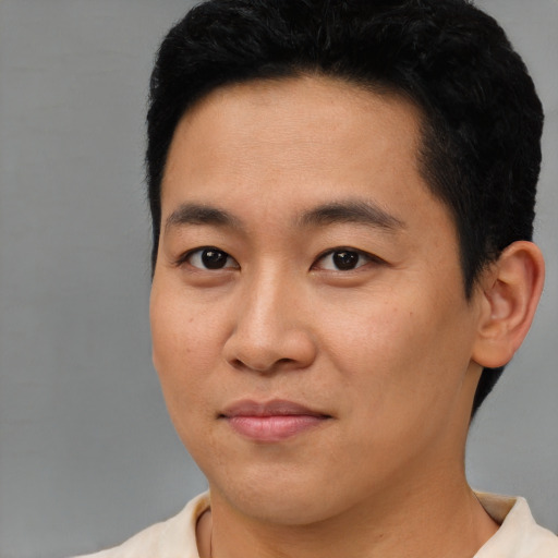Joyful asian young-adult male with short  black hair and brown eyes