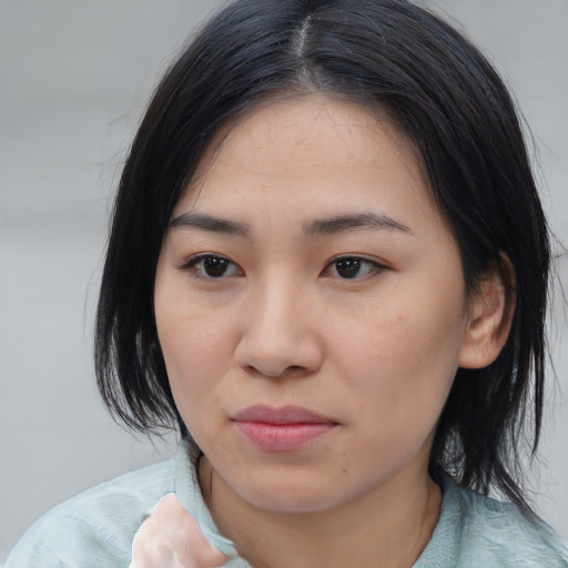 Joyful asian young-adult female with medium  black hair and brown eyes
