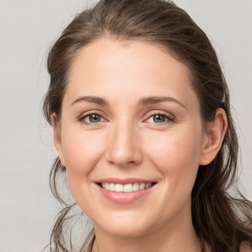 Joyful white young-adult female with medium  brown hair and grey eyes