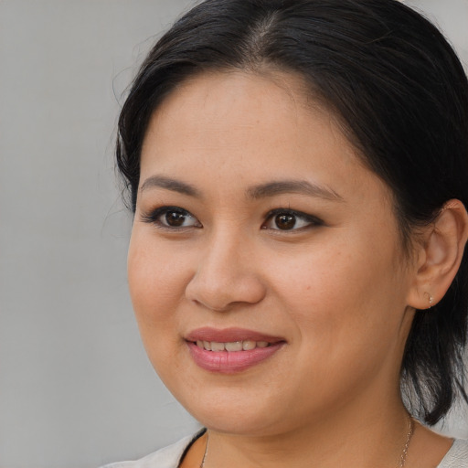 Joyful latino young-adult female with medium  brown hair and brown eyes