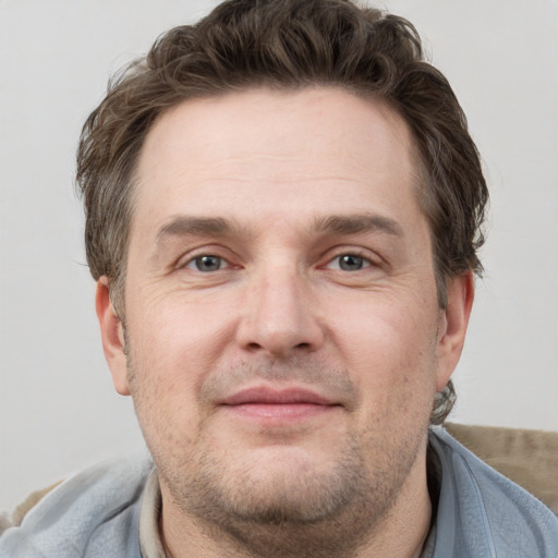 Joyful white adult male with short  brown hair and grey eyes