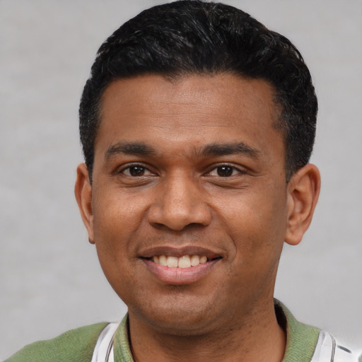 Joyful latino young-adult male with short  black hair and brown eyes