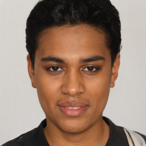Joyful black young-adult male with short  black hair and brown eyes