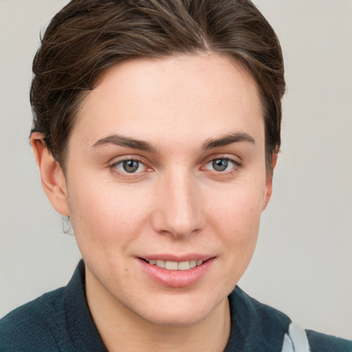 Joyful white young-adult female with short  brown hair and grey eyes