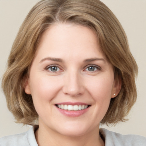 Joyful white young-adult female with medium  brown hair and blue eyes