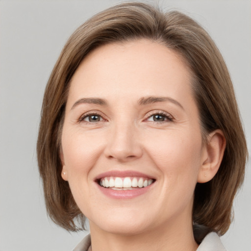 Joyful white young-adult female with medium  brown hair and grey eyes