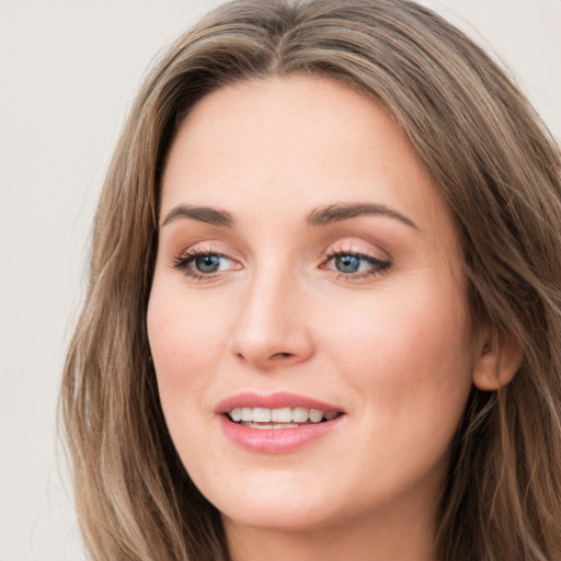 Joyful white young-adult female with long  brown hair and grey eyes