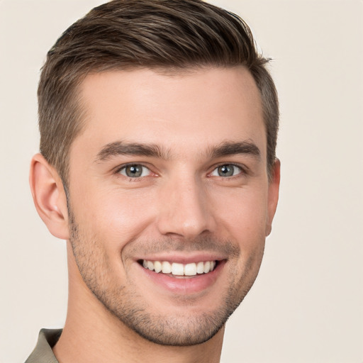 Joyful white young-adult male with short  brown hair and grey eyes