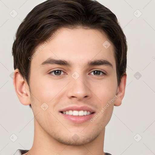 Joyful white young-adult male with short  brown hair and grey eyes