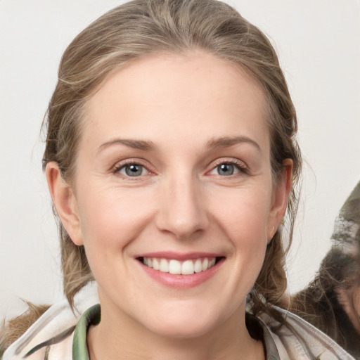 Joyful white young-adult female with medium  brown hair and grey eyes