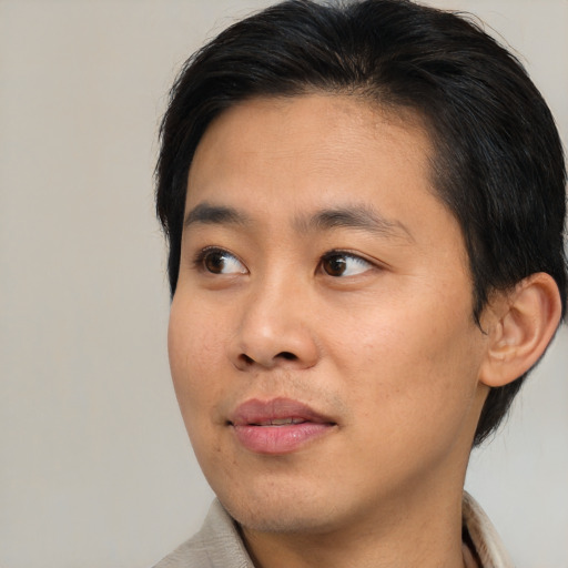 Joyful asian young-adult male with short  brown hair and brown eyes