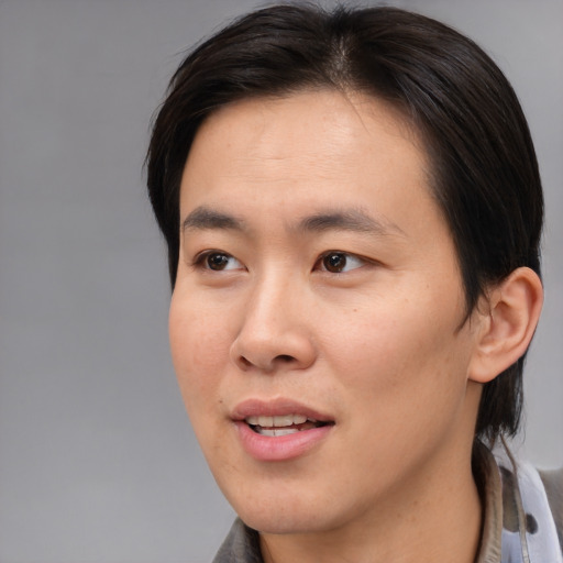 Joyful asian young-adult male with medium  brown hair and brown eyes