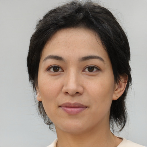 Joyful asian adult female with medium  black hair and brown eyes