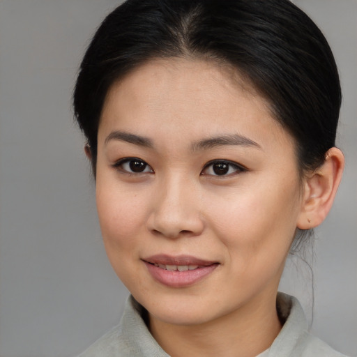 Joyful asian young-adult female with medium  brown hair and brown eyes