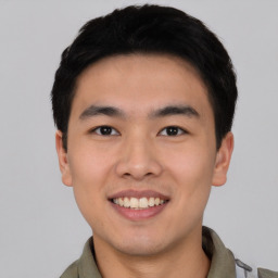 Joyful asian young-adult male with short  black hair and brown eyes