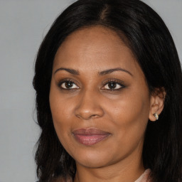 Joyful black adult female with long  brown hair and brown eyes