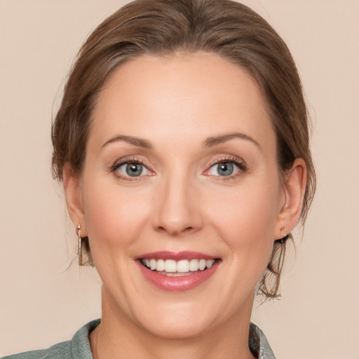 Joyful white young-adult female with medium  brown hair and grey eyes