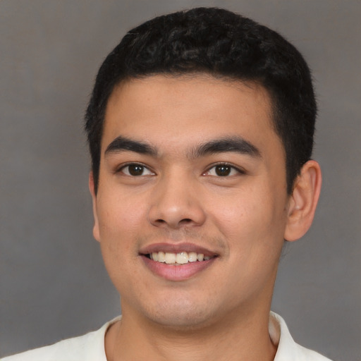 Joyful latino young-adult male with short  black hair and brown eyes