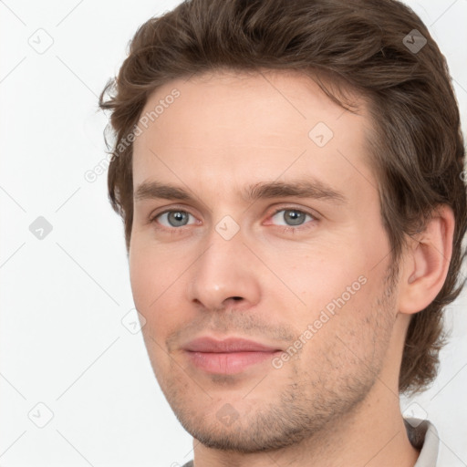 Joyful white young-adult male with short  brown hair and grey eyes