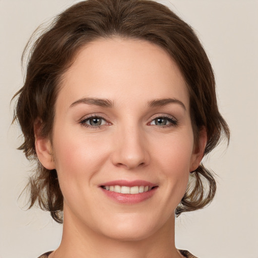 Joyful white young-adult female with medium  brown hair and grey eyes