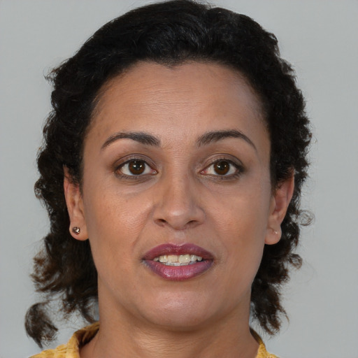 Joyful black adult female with medium  brown hair and brown eyes