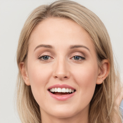 Joyful white young-adult female with long  brown hair and blue eyes