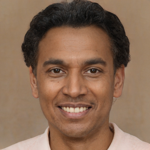 Joyful latino adult male with short  black hair and brown eyes