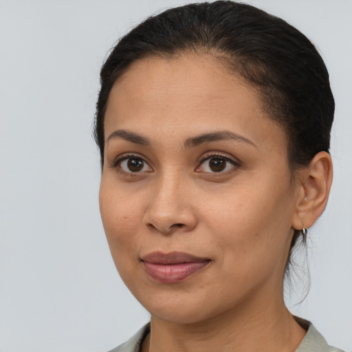 Joyful latino young-adult female with medium  brown hair and brown eyes