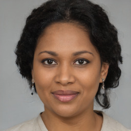 Joyful black young-adult female with long  brown hair and brown eyes