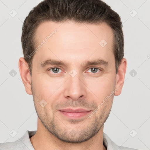 Joyful white young-adult male with short  brown hair and grey eyes