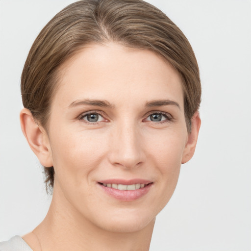 Joyful white young-adult female with short  brown hair and grey eyes