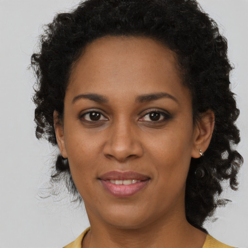 Joyful black young-adult female with short  brown hair and brown eyes