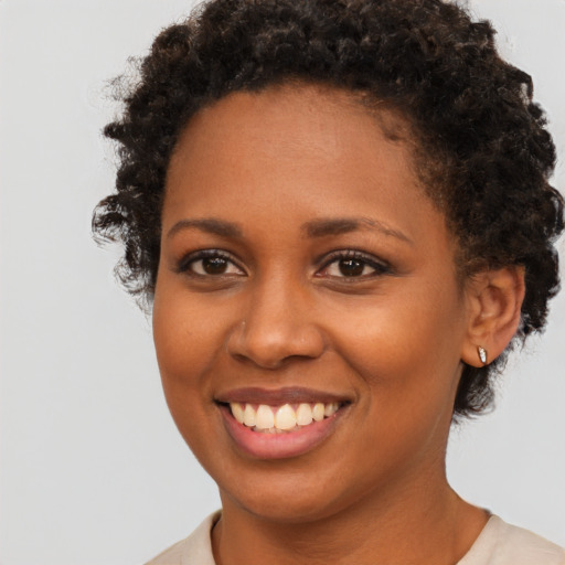 Joyful black young-adult female with short  brown hair and brown eyes