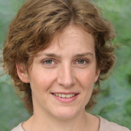 Joyful white adult female with medium  brown hair and green eyes