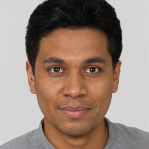 Joyful black young-adult male with short  black hair and brown eyes