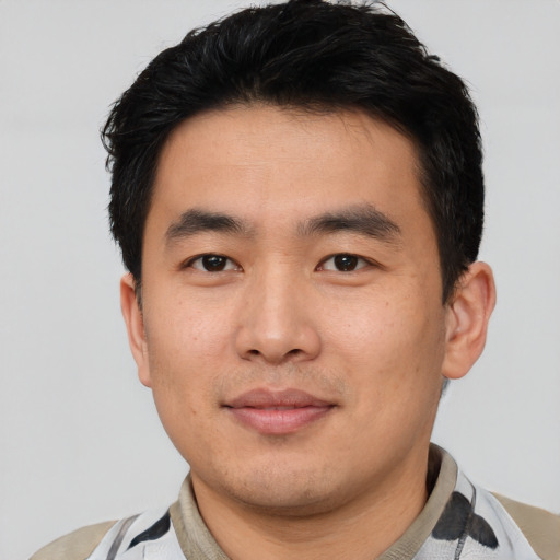 Joyful asian young-adult male with short  black hair and brown eyes