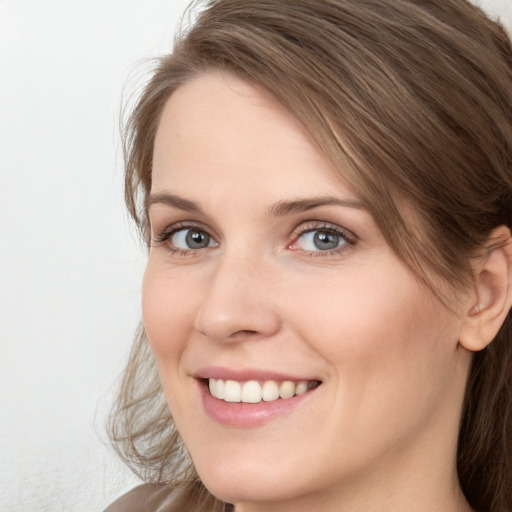 Joyful white young-adult female with long  brown hair and grey eyes