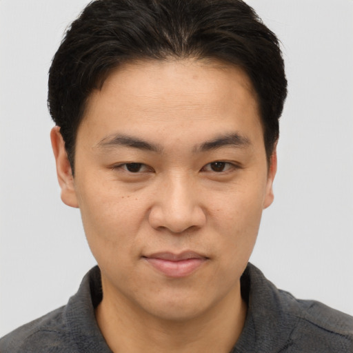 Joyful asian young-adult male with short  brown hair and brown eyes