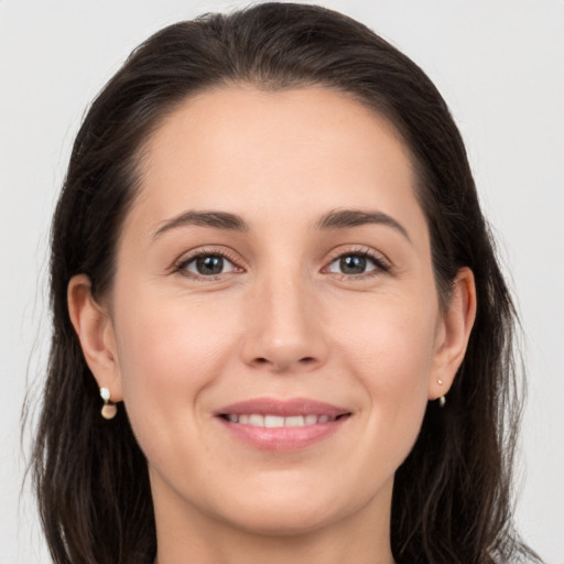 Joyful white young-adult female with long  brown hair and brown eyes