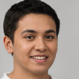 Joyful latino young-adult male with short  brown hair and brown eyes