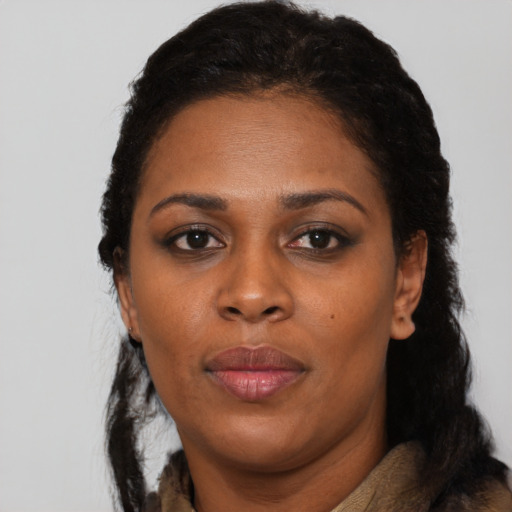 Joyful black adult female with long  black hair and brown eyes