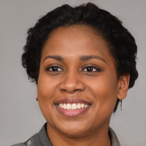 Joyful black adult female with short  brown hair and brown eyes