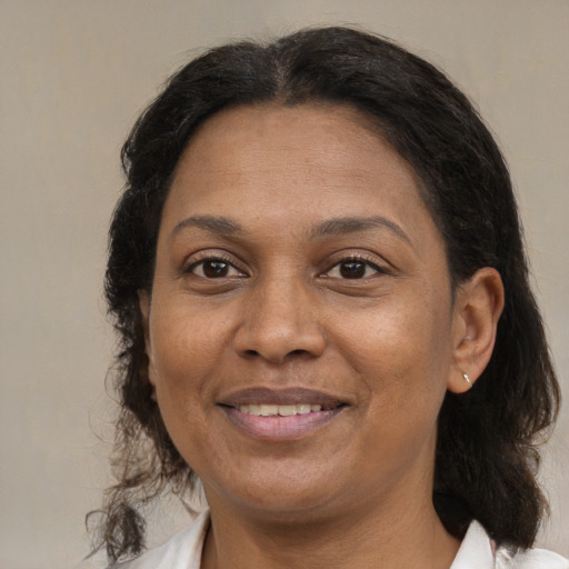 Joyful latino adult female with medium  brown hair and brown eyes