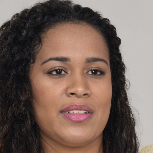 Joyful black young-adult female with long  brown hair and brown eyes