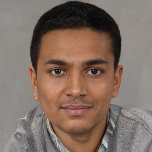 Joyful latino young-adult male with short  brown hair and brown eyes
